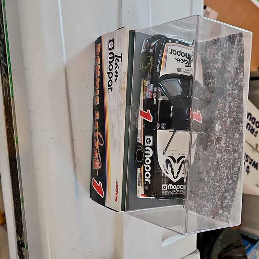 Black diecast truck in clear display box with logo graphics