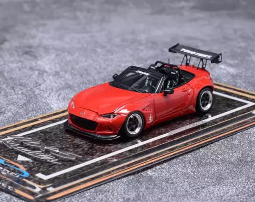 Red convertible diecast roadster model car with black wheels and rear spoiler.