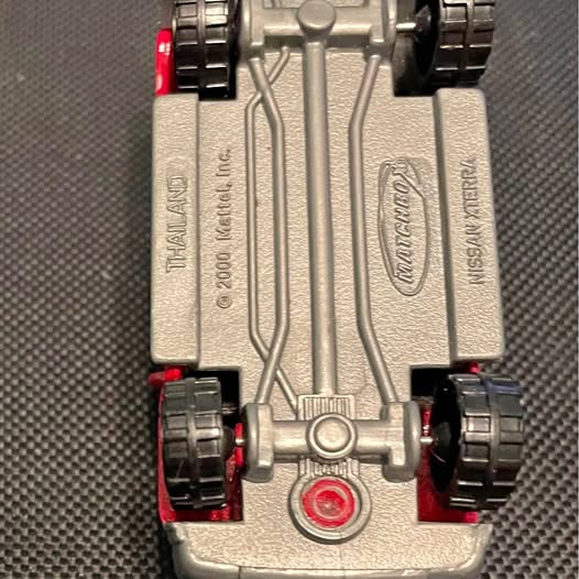 Matchbox Nissan Xterra diecast vehicle underside with silver chassis and red wheels