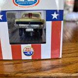 Diecast race car model front view with black grille and yellow roof, in display box