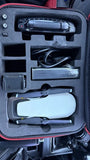 Compact quadcopter drone in foam-lined carrying case, propellers visible