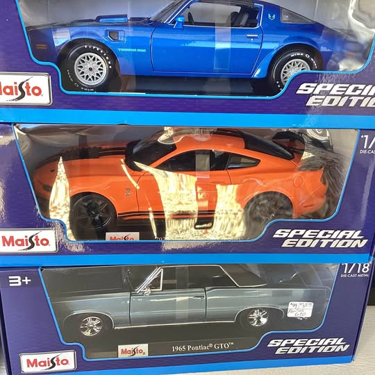 1:18 diecast car model in box, dark green-blue 1965 Pontiac GTO, left-side view