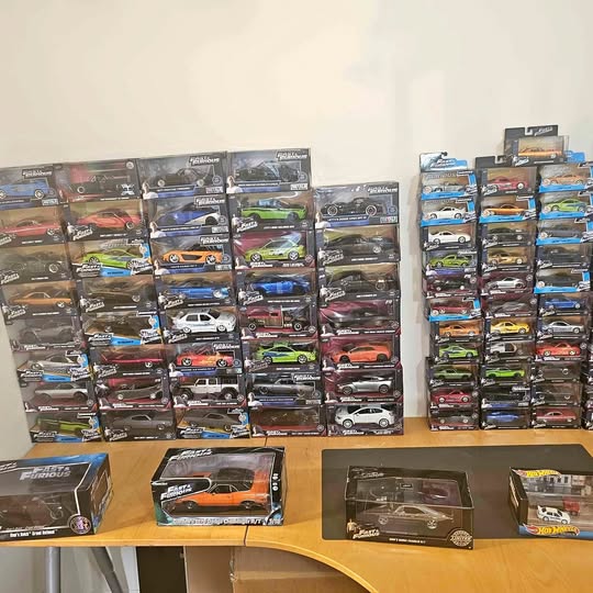 Diecast car lot with many boxed vehicles, assorted colors