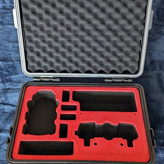 Hard carrying case with red foam insert and molded compartments