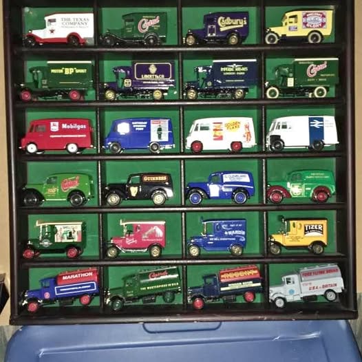 Diecast collectible vehicle set in green display tray with multiple miniature cars and trucks