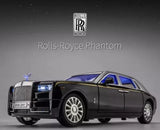 Diecast model car of a dark luxury sedan with blue headlights and detailed alloy wheels