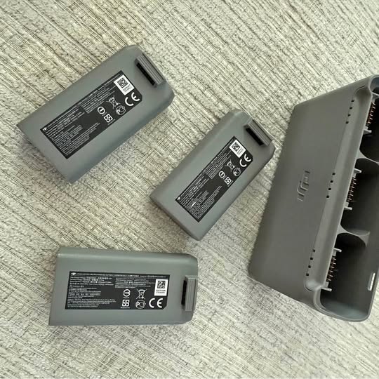 Drone battery charger with three gray batteries and charging bay