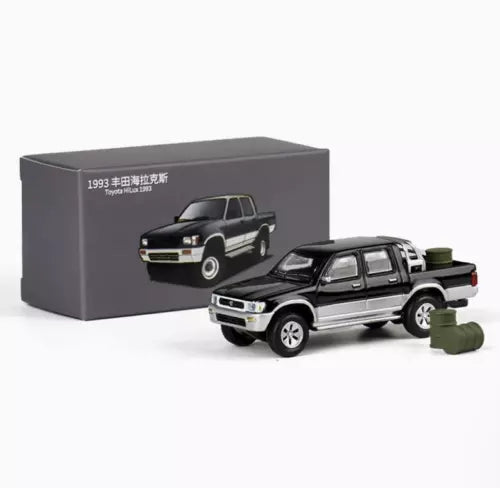 Black 1:64 diecast Toyota Hilux pickup truck model with display box
