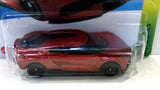 Diecast sports car model in dark orange with black wheels, front view in blister