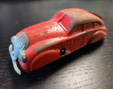 Red tin wind-up toy sedan with open grille, front three-quarter view
