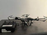 Remote control drone with black quadcopter body and attached controller, front camera visible