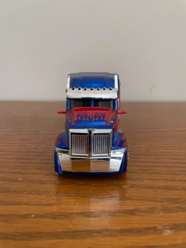 Optimus Prime diecast truck, blue cab with chrome grille and red flame stripe