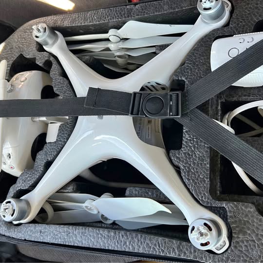 White quadcopter drone with four propeller arms and gimbal body mount