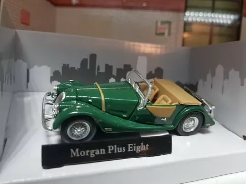 Green diecast model car on display base with cream interior, chrome details
