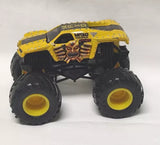 Yellow diecast monster truck with skull graphics, oversized black tires and yellow rims