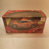 Orange 1:24 diecast race car with wheels, shown in retail display box
