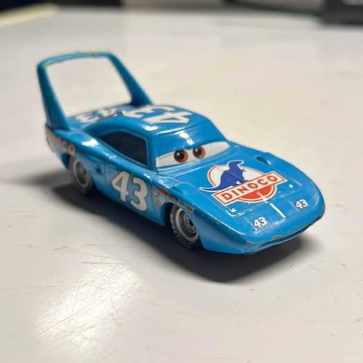 Blue diecast race car with number 43 and Dinoco logo, front-left view