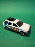 White diecast model car with blue and orange graphics, black wheels and roof rack