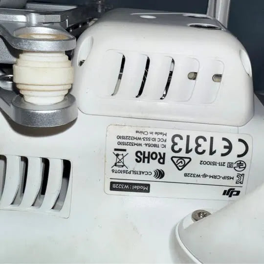 White quadcopter drone body with certification label and front landing gear