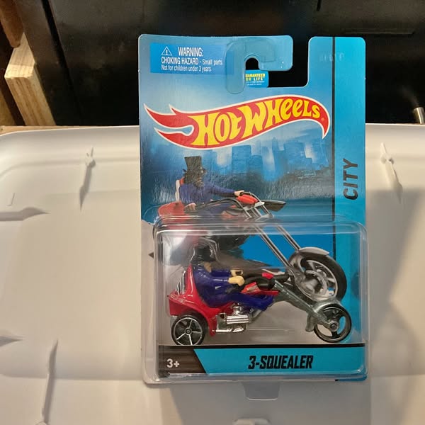 Hot Wheels diecast 3-Squealer motorcycle with rider, red and black, on blister card