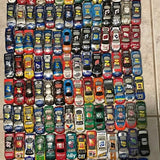 Assorted 1/64 scale diecast cars, various colors and designs on display
