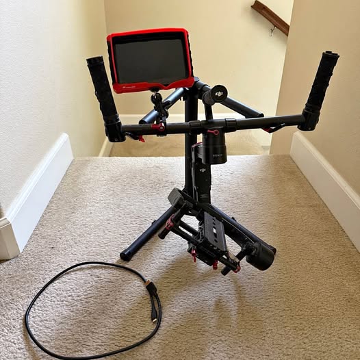 Black quadcopter drone with open red-trim carrying case and mounted camera
