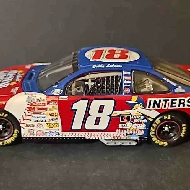 Diecast racing car with #18 red and blue livery, front 3/4 view, sponsor decals