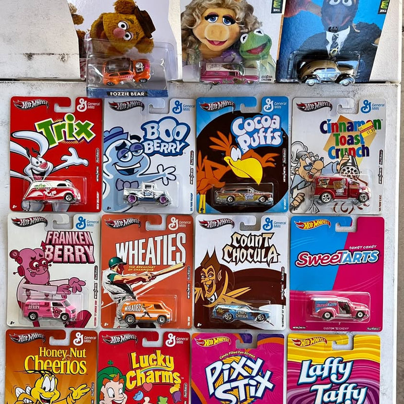Hot Wheels diecast car blister packs in colorful cereal-themed boxes