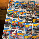 Assorted 1:64 diecast car models on retail blister packaging, Hot Wheels-style