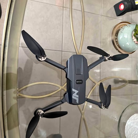 Compact quadcopter drone with four black propellers and dark gray body