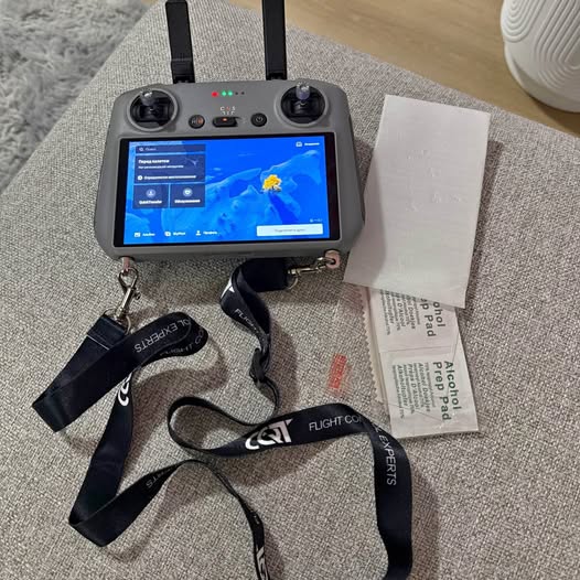 Drone remote controller with touchscreen display, two antennas, and wrist strap