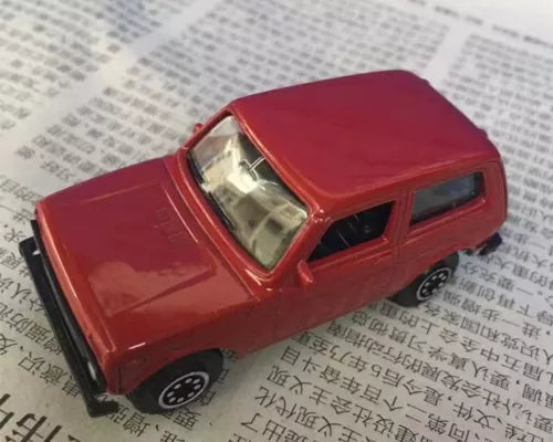 Red diecast car model with detailed front grille and headlights
