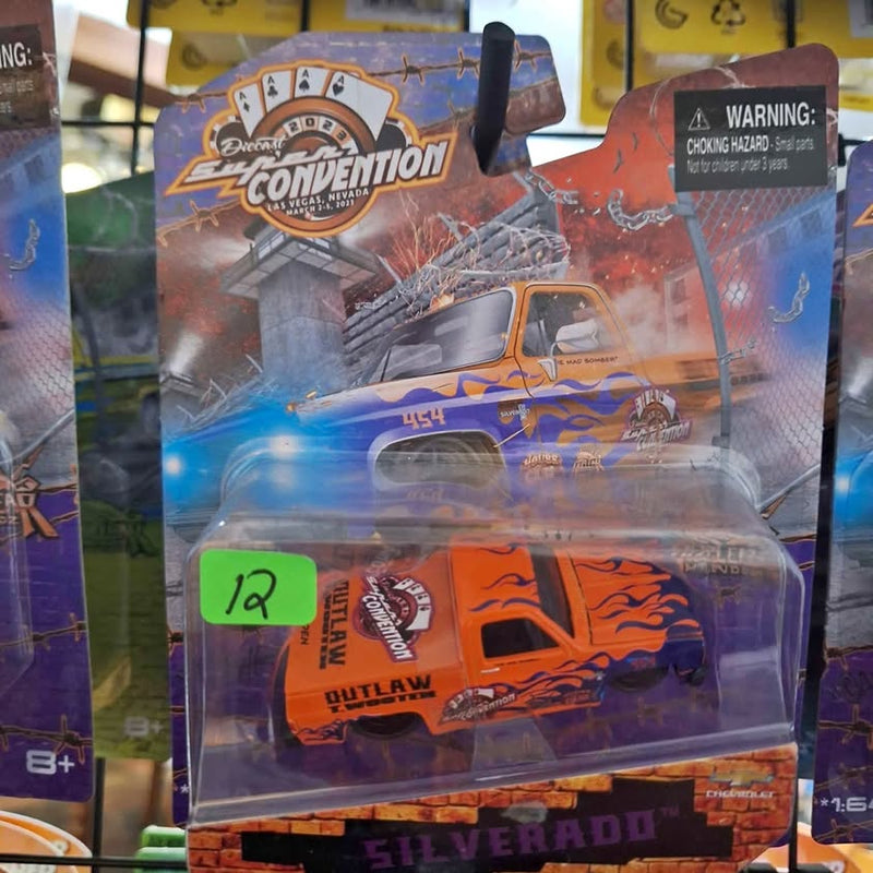 Diecast toy car in blister pack, orange and black flame graphics, Outlaw design