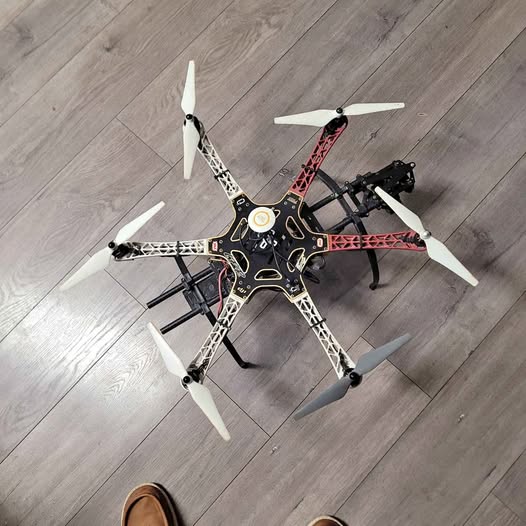 Foldable quadcopter drone with four propellers and red-accent frame