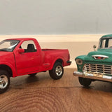 Red and green diecast pickup truck models, front three-quarter view