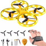Yellow hand-controlled quadcopter drone with four propellers and controller in hand