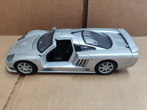 Silver diecast sports car model with open side doorway, 1:24 scale