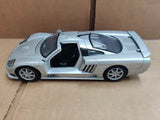 Silver diecast sports car model with open side doorway, 1:24 scale