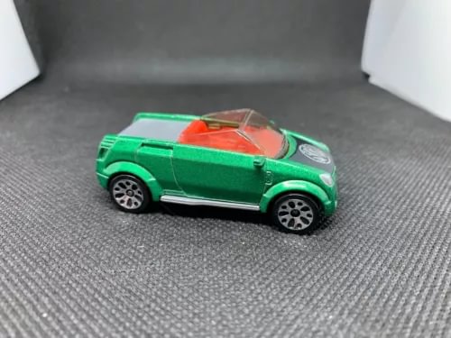 Green diecast model car, 3/4 view, red interior, detailed wheels and body.