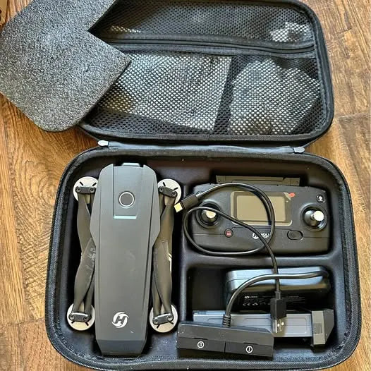 Open hard-shell drone case with gray quadcopter, controller, and cables