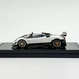 1:64 scale white metal sports car model with black accents and gold wheels, side view