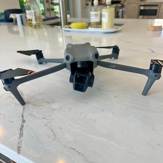 DJI Air 3 drone with front camera and four propeller arms, gray and black body