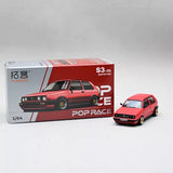Red 1/64 diecast model car in box, with small red car figure beside it