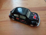 Black classic Beetle diecast model car with colorful heart decals, side view