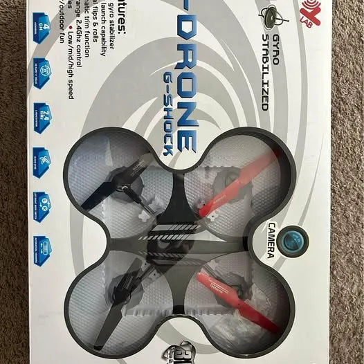 Drone toy with four propellers, red and black arms, shown on retail packaging
