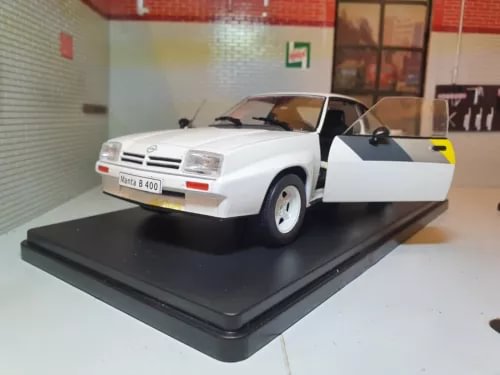 White 1:24 diecast sports car model with open driver door, front three-quarter view