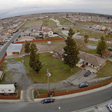 Quadcopter drone in flight over neighborhood streets