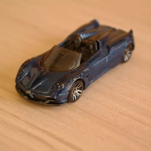 Diecast roadster toy car, dark blue with detailed silver wheels