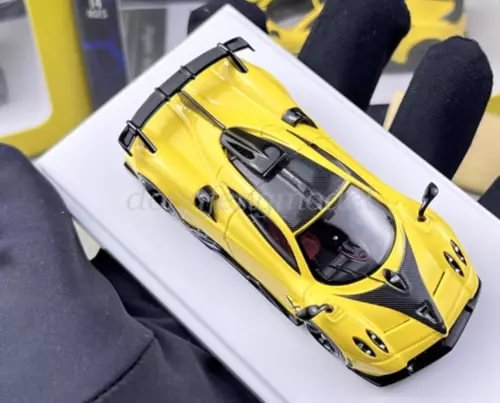 Yellow race sports diecast metal model car with black aero details and clear windows