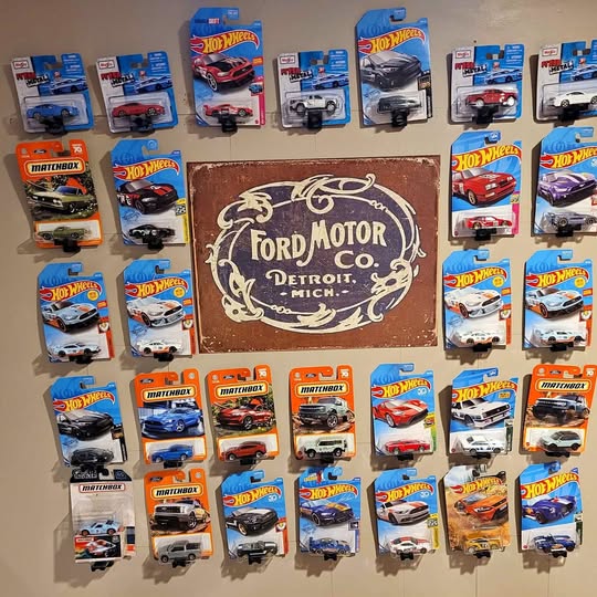 Diecast model display mount with large Ford Motor Detroit oval logo, brown backing